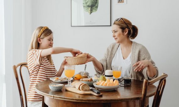 A warm family breakfast with mother and daughter sharing a meal in a cozy dining area.
